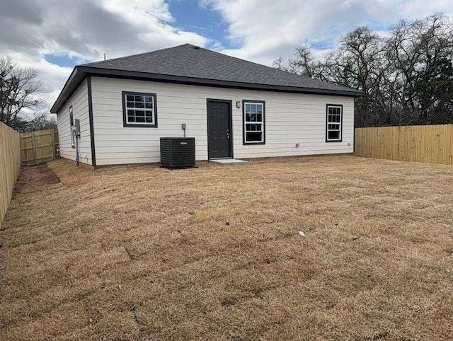 3513 Tomahawk Drive, Granbury, TX 76048 Rear exterior featuring light-colored horizontal siding with black trim, dark shingle roof, and a dark entry door