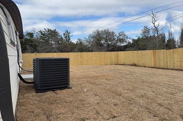 3513 Tomahawk Drive, Granbury, TX 76048 Expansive backyard featuring a newly installed wood privacy fence, a modern outdoor HVAC unit, and a broad grassy area
