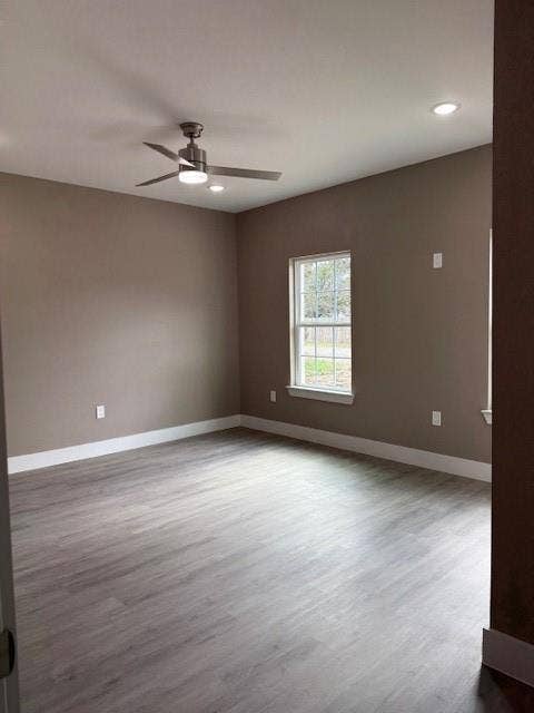 3513 Tomahawk Drive, Granbury, TX 76048 Spacious room featuring wood-finish flooring, a contemporary ceiling fan, recessed lighting, and a double-pane window with a white frame