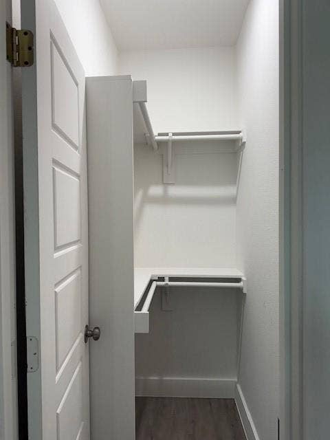 3513 Tomahawk Drive, Granbury, TX 76048 Walk-in closet featuring white walls, shelving, and clothing rods, complemented by wood-finish flooring and white baseboards