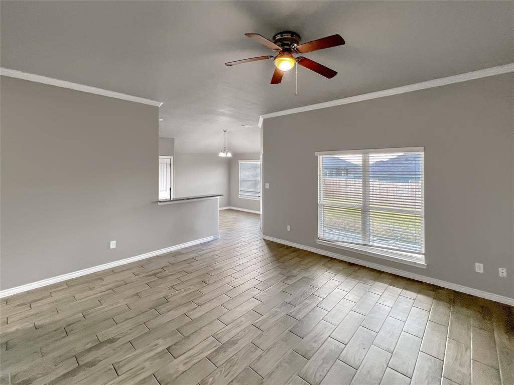 1210 Campbelton Drive, Temple, TX 76504 Spacious room featuring wood-look tile flooring, a ceiling fan with integrated lighting, and a large window