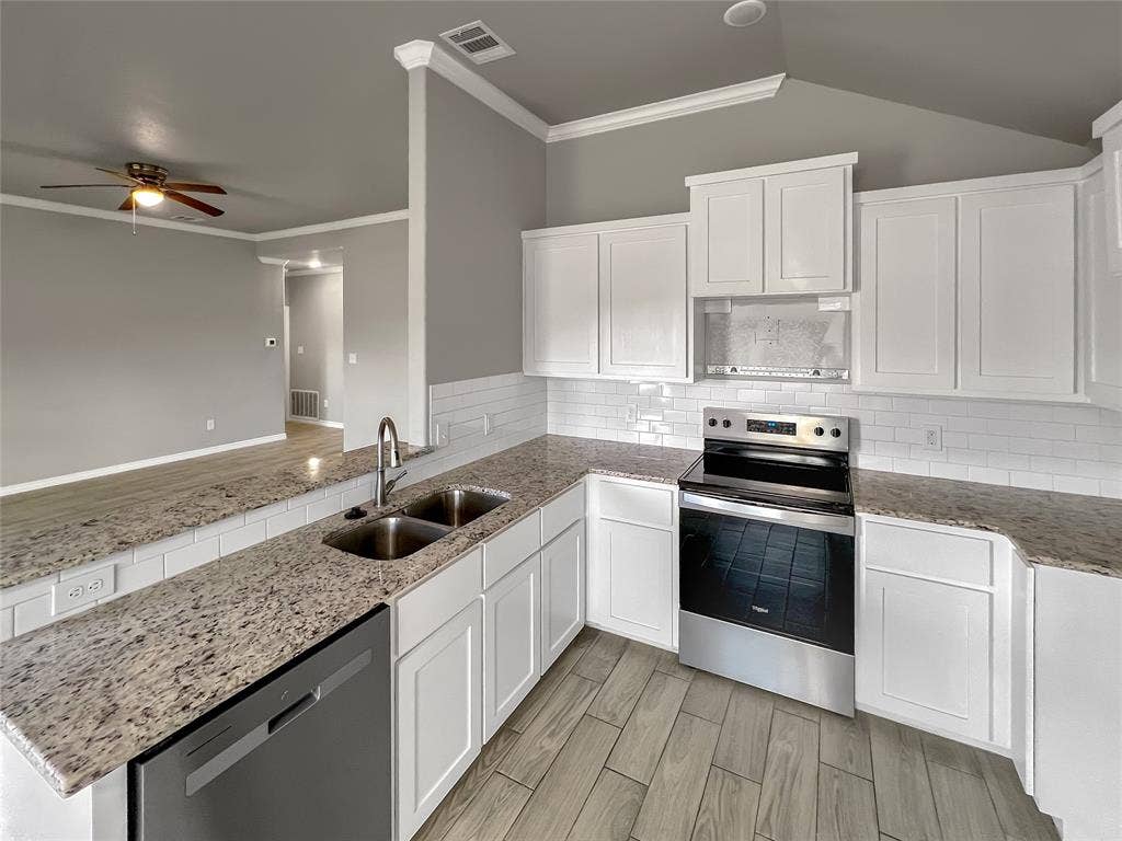 1210 Campbelton Drive, Temple, TX 76504 Modern kitchen featuring white shaker cabinetry, stainless steel appliances, granite-look countertops, subway tile backsplash, and wood-finish flooring