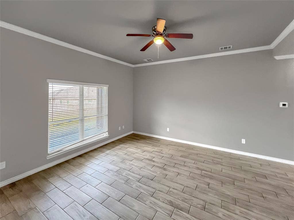 1210 Campbelton Drive, Temple, TX 76504 Spacious living area featuring a ceiling fan with integrated lighting, crown molding, and a large window with horizontal blinds