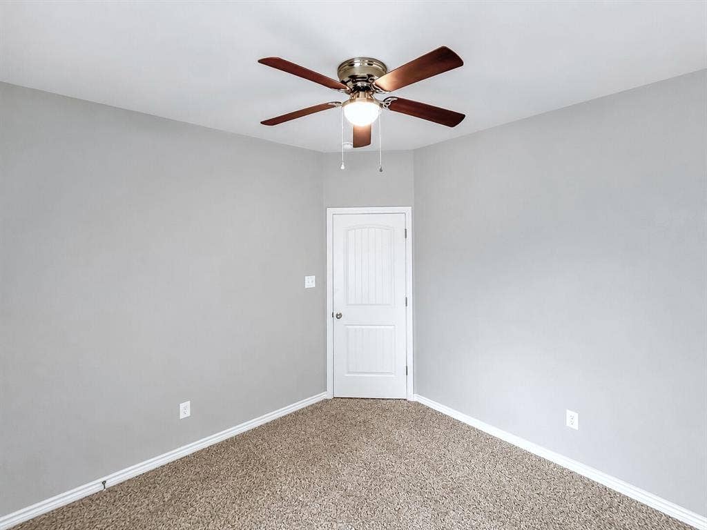 1210 Campbelton Drive, Temple, TX 76504 Neutral gray wall paint, textured carpet flooring, and a white six-panel door with brushed nickel hardware
