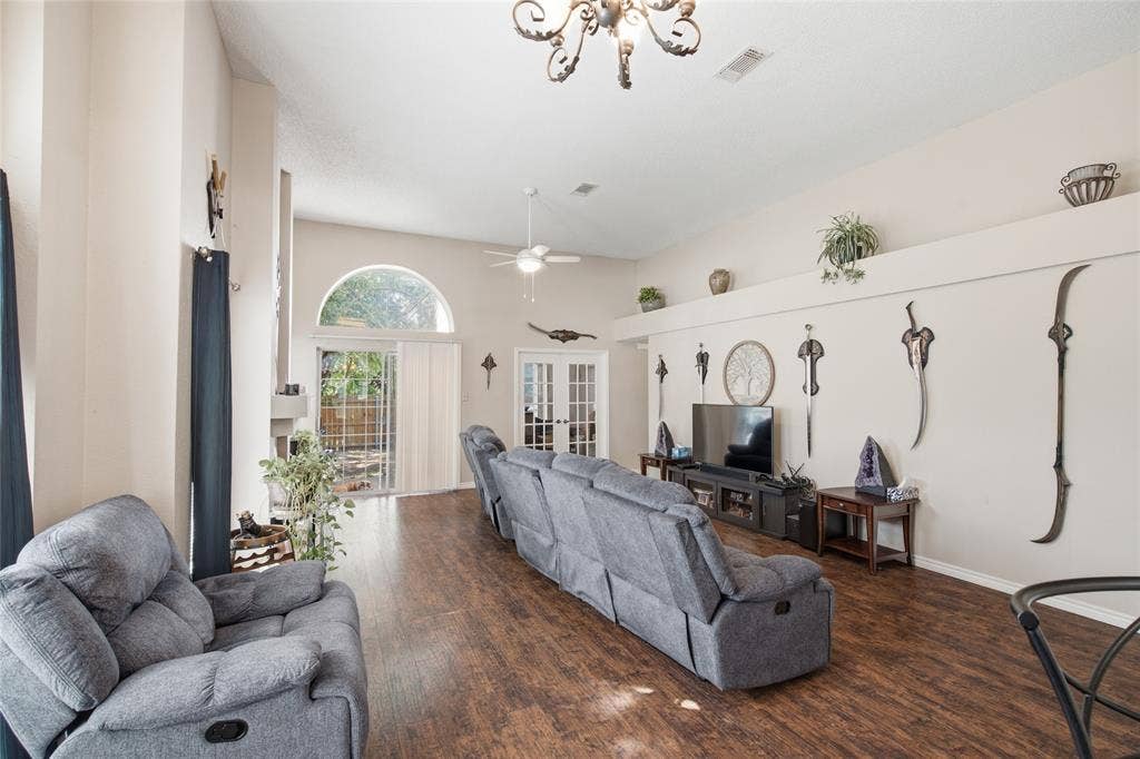 1106 Cain Court, Cedar Hill, TX 75104 Spacious living area featuring wood-finish flooring, vaulted ceilings, and a decorative chandelier