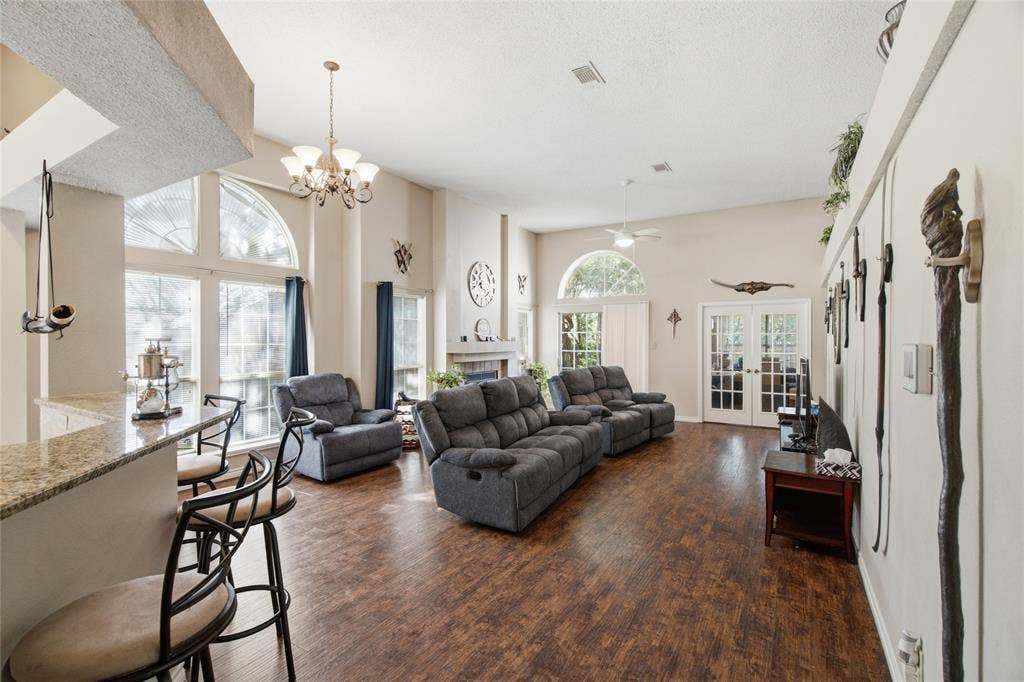 1106 Cain Court, Cedar Hill, TX 75104 Spacious living area featuring high vaulted ceilings, wood-finish flooring, and a fireplace with a mantel