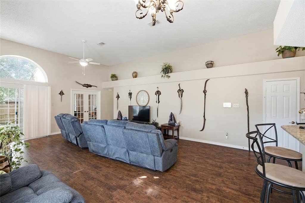 1106 Cain Court, Cedar Hill, TX 75104 Spacious living area featuring wood-finish flooring, vaulted ceilings, and a decorative chandelier