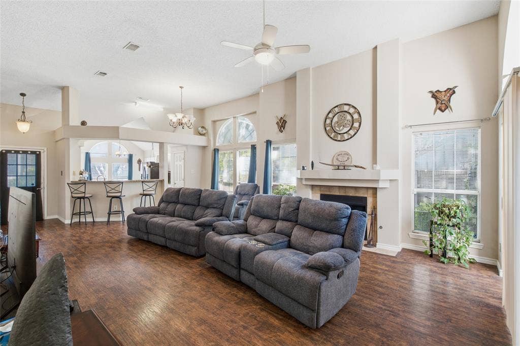 1106 Cain Court, Cedar Hill, TX 75104 Spacious living area featuring wood-finish flooring, a ceiling fan, and a fireplace with mantel