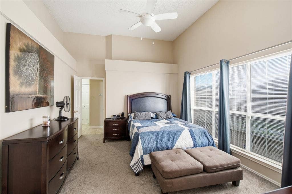 1106 Cain Court, Cedar Hill, TX 75104 Carpeted bedroom with a vaulted ceiling, ceiling fan, and two large windows