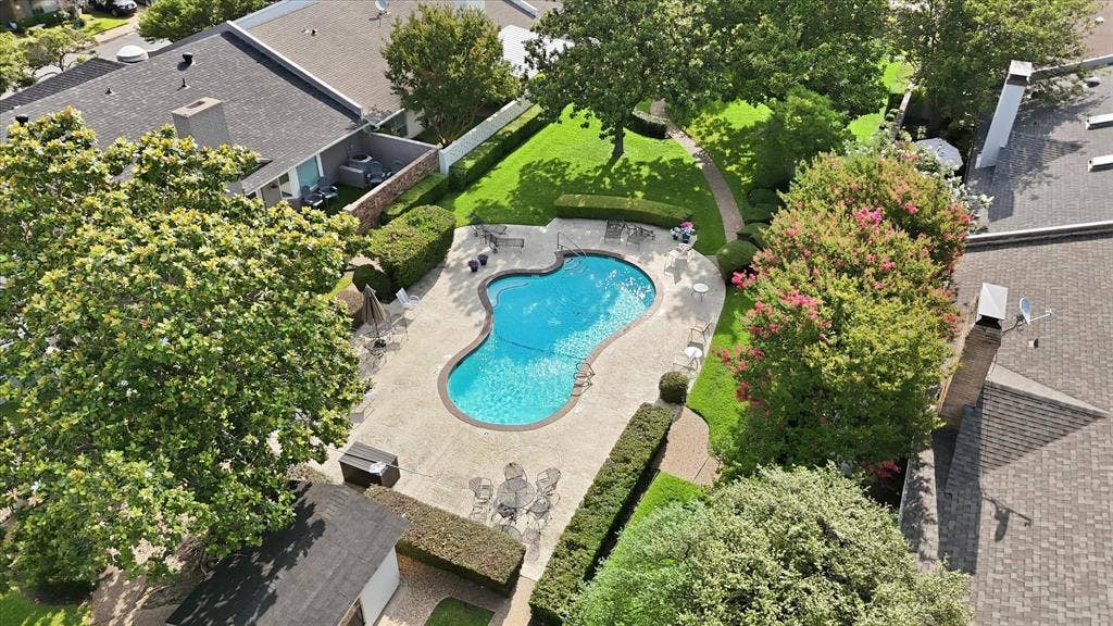4310 Forest Bend Road, Dallas, TX 75244 Freeform swimming pool surrounded by a spacious concrete patio and manicured lawn