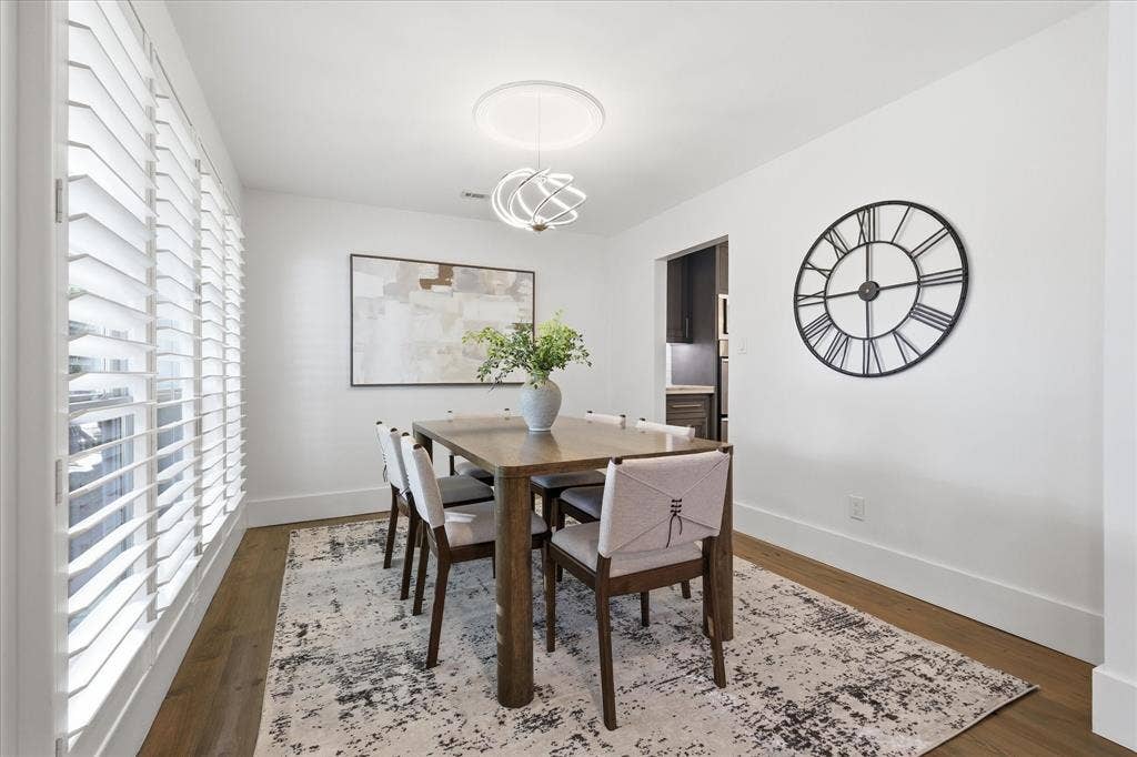 4310 Forest Bend Road, Dallas, TX 75244 Dining area featuring wood-finish flooring, white plantation shutters, a contemporary chandelier, and crisp white walls