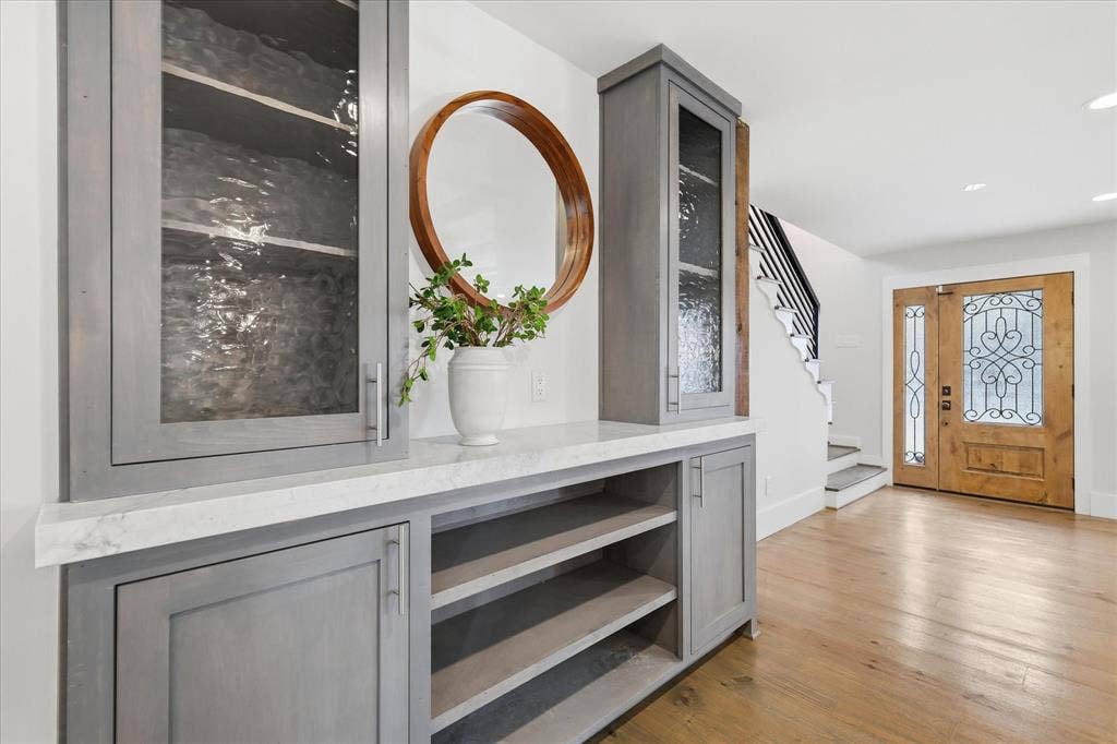 4310 Forest Bend Road, Dallas, TX 75244 Built-in cabinetry with a light gray finish, textured glass panels, and a light-toned countertop