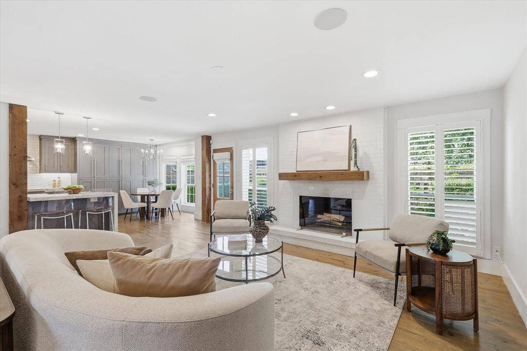 4310 Forest Bend Road, Dallas, TX 75244 Living area featuring a white brick fireplace with a wood mantel, plantation shutters, and recessed lighting