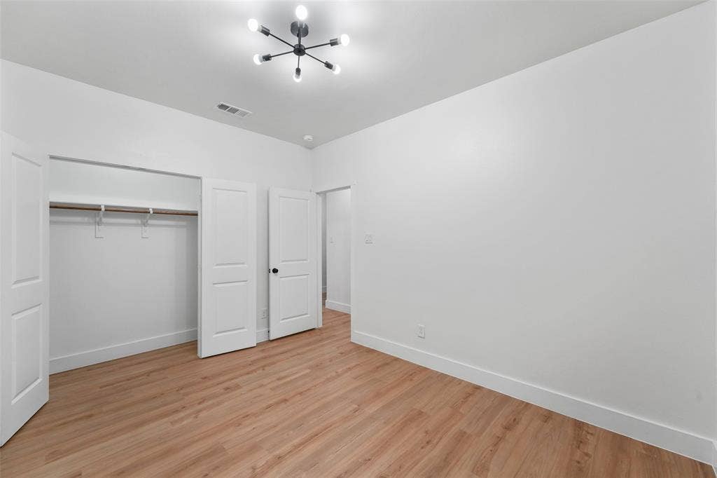 117 Parkside Drive, Trinidad, TX 75163 Spacious interior room featuring wood-finish flooring, white walls, and a contemporary ceiling light fixture