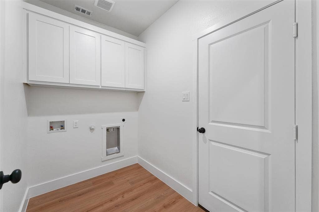 117 Parkside Drive, Trinidad, TX 75163 Laundry area featuring wood-finish flooring, white shaker-style cabinetry, and crisp white walls
