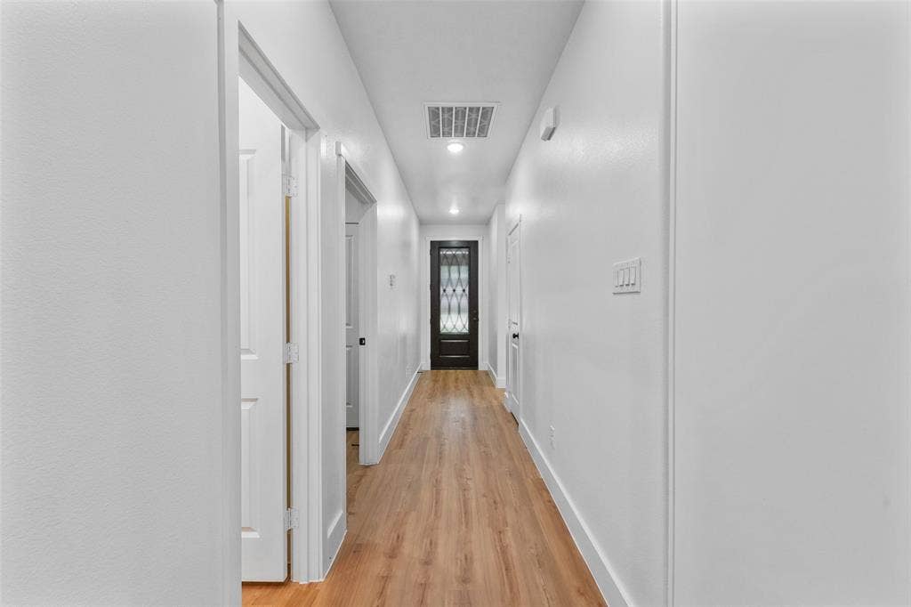 117 Parkside Drive, Trinidad, TX 75163 Hallway featuring wood-finish flooring, recessed lighting, white walls, and a black paneled door with decorative glass