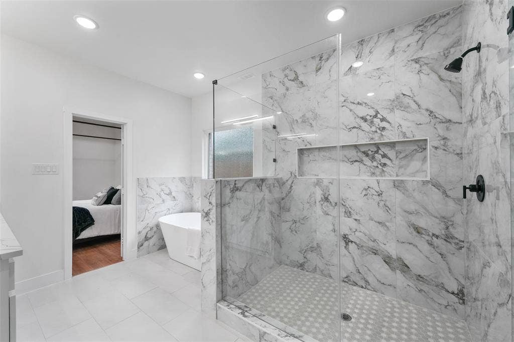 117 Parkside Drive, Trinidad, TX 75163 Spacious bathroom featuring a frameless glass shower enclosure with marble-finish tile walls and a built-in shower niche