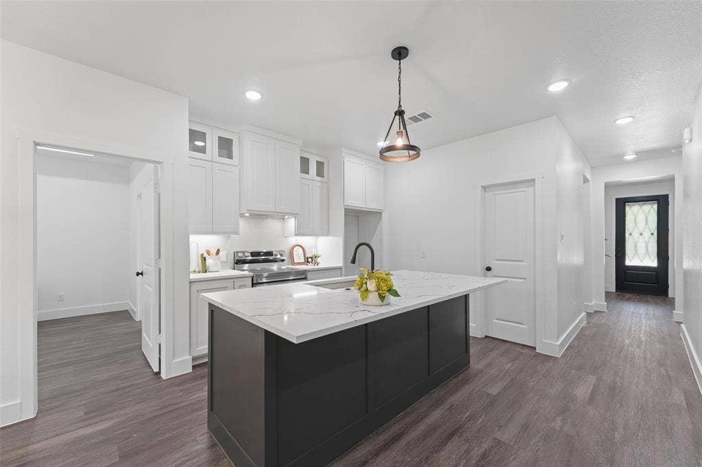 122 E Beachwood Loop, Trinidad, TX 75163 Modern kitchen featuring white shaker cabinetry, stainless steel appliances, a black kitchen island with a white countertop, and wood-finish flooring