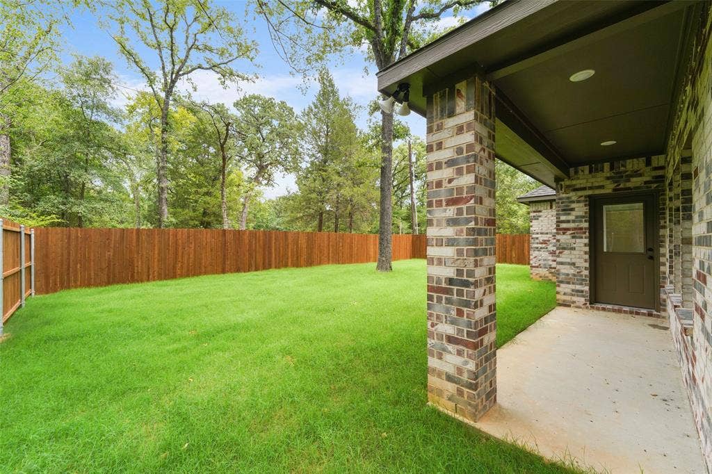122 E Beachwood Loop, Trinidad, TX 75163 Expansive backyard featuring a lush lawn and wood privacy fencing