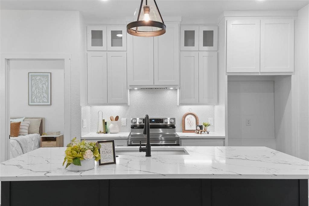 122 E Beachwood Loop, Trinidad, TX 75163 Kitchen island featuring a white countertop with grey veining, a matte black sink faucet, stainless steel range, white shaker-style cabinetry, and a white hexagonal tile backsplash