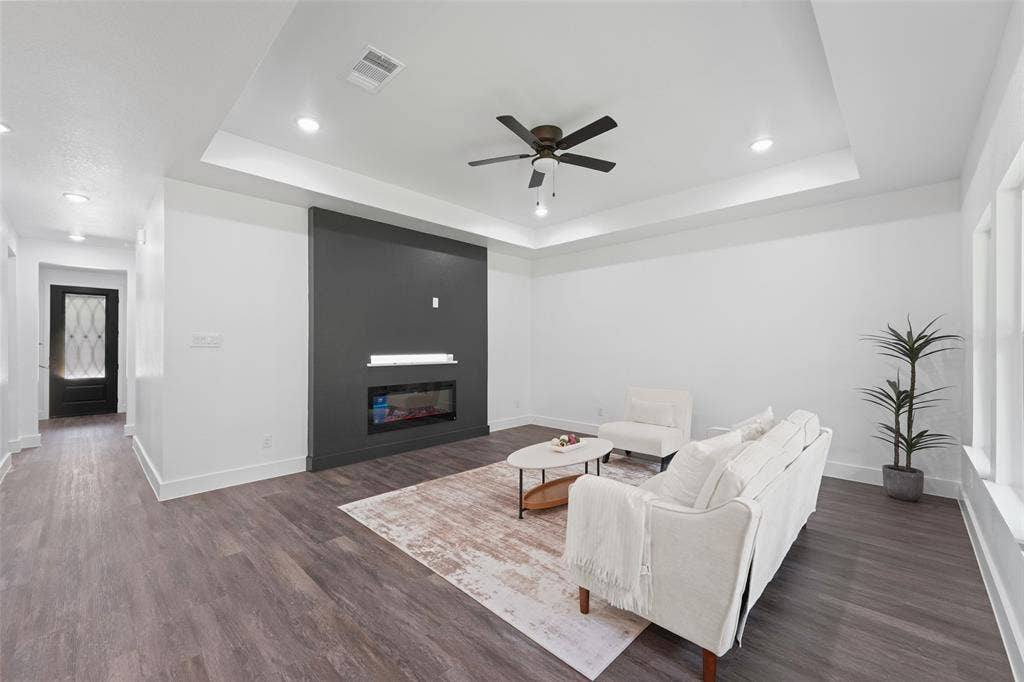 122 E Beachwood Loop, Trinidad, TX 75163 Living area featuring wood-finish flooring, a tray ceiling with a ceiling fan, recessed lighting, and a modern linear fireplace set into a dark accent wall