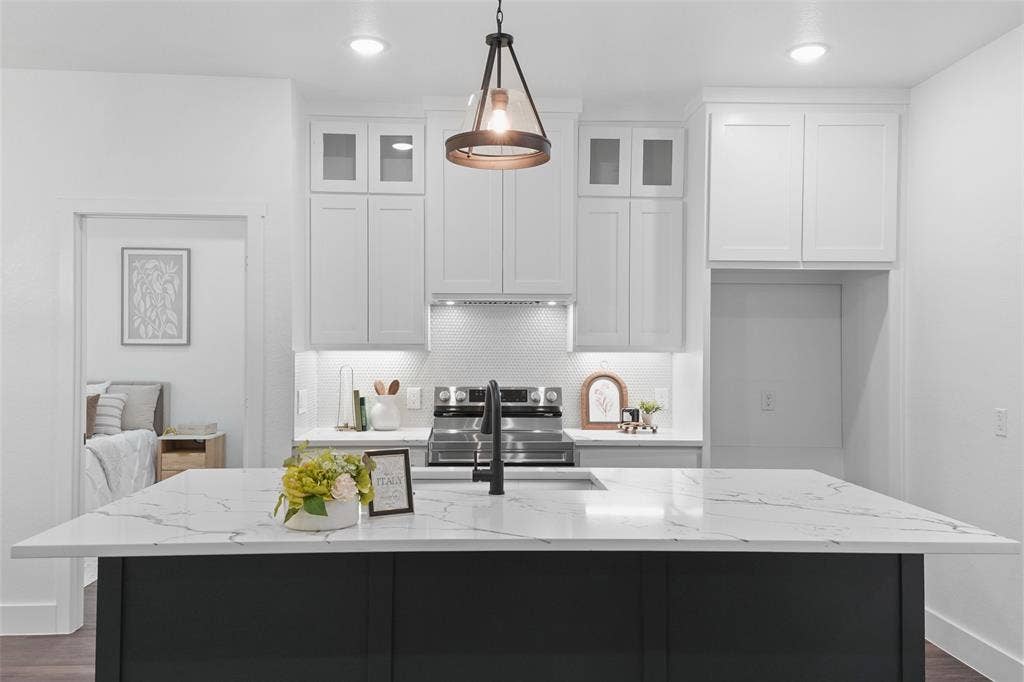 122 E Beachwood Loop, Trinidad, TX 75163 Spacious kitchen featuring a large island with a stone-finish countertop, white upper cabinetry with glass-front accents, dark lower cabinetry, and recessed lighting