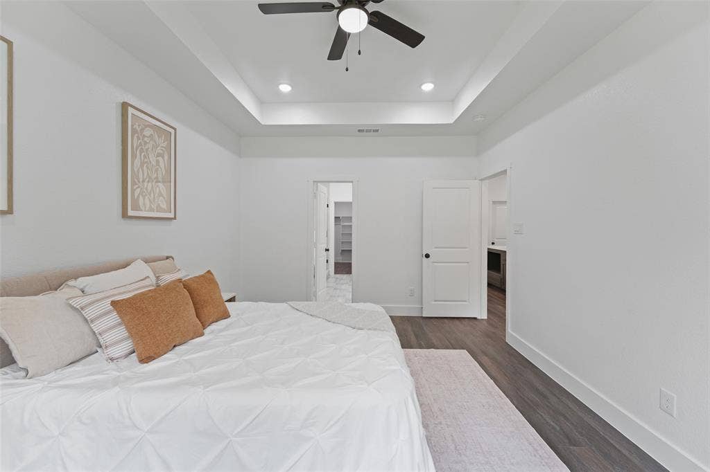 122 E Beachwood Loop, Trinidad, TX 75163 Spacious bedroom featuring a tray ceiling with recessed lighting and a ceiling fan, wood-finish flooring, and white interior doors with dark hardware