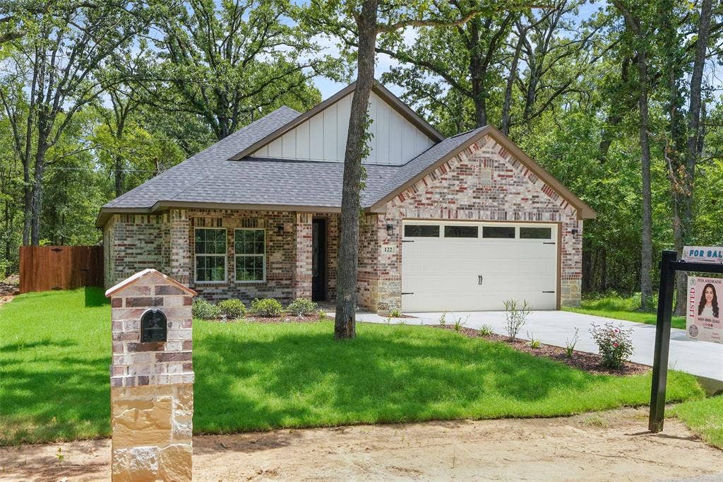 122 E Beachwood Loop, Trinidad, TX 75163 Brick and stone facade residence featuring a dark shingle roof, a two-car garage, and a manicured lawn