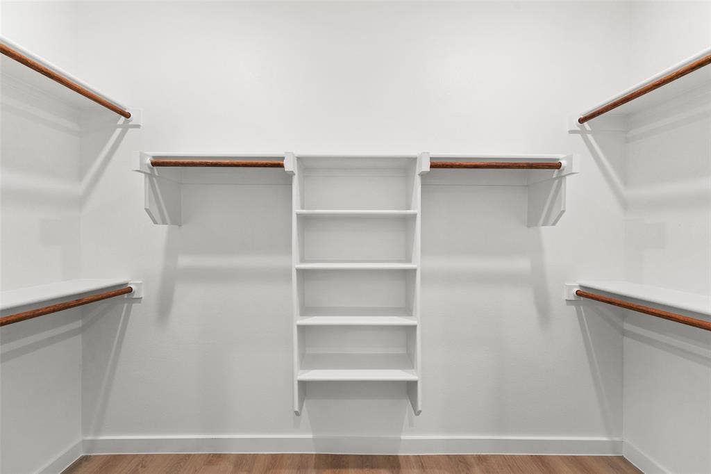 231 E Beachwood Loop, Trinidad, TX 75163 Walk-in closet featuring white built-in shelving, multiple hanging rods, and wood-finish flooring