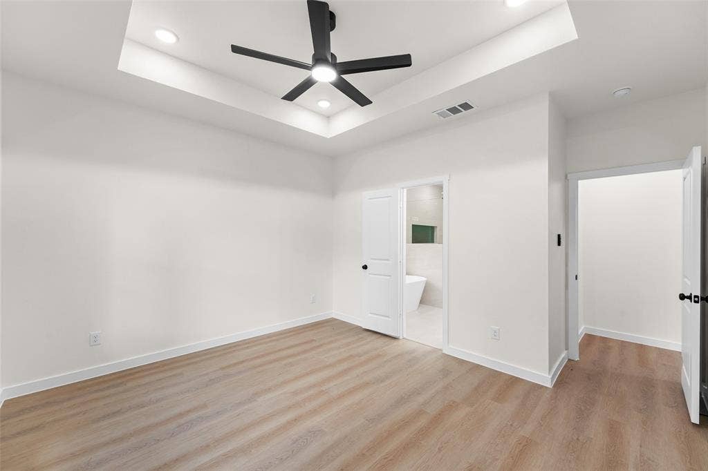 231 E Beachwood Loop, Trinidad, TX 75163 Spacious room featuring wood-finish flooring, a tray ceiling with recessed lighting, and a contemporary black ceiling fan