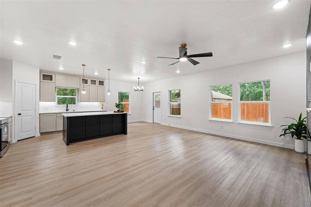 231 E Beachwood Loop, Trinidad, TX 75163 Open-concept living space featuring wood-finish flooring, a contemporary kitchen island with a dark finish, light-toned cabinetry, and recessed lighting