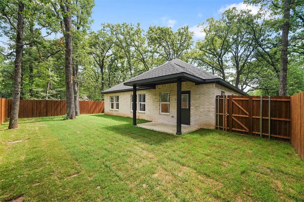 231 E Beachwood Loop, Trinidad, TX 75163 Expansive backyard featuring a manicured lawn and mature trees
