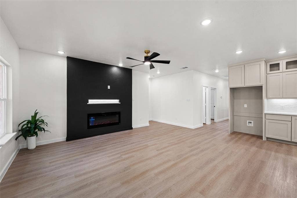 231 E Beachwood Loop, Trinidad, TX 75163 Spacious open-concept living area featuring an accent wall with a built-in electric fireplace and display ledge