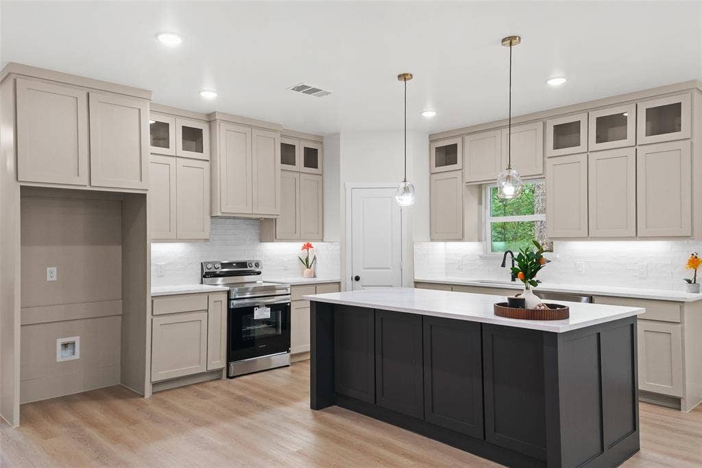 231 E Beachwood Loop, Trinidad, TX 75163 Kitchen featuring a spacious island with a white countertop, two-tone cabinetry, stainless steel range, wood-finish flooring, and pendant lighting