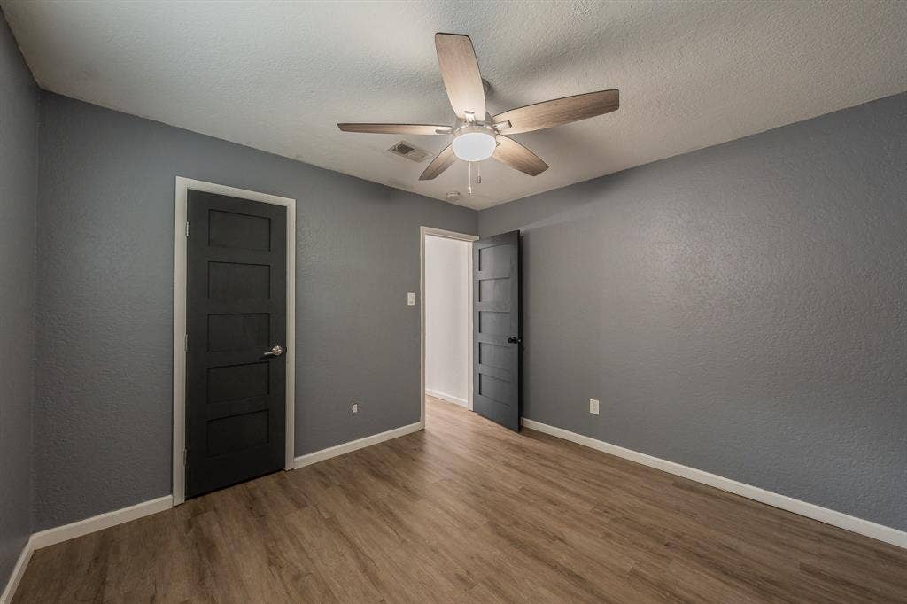 5612 Macgregor Drive, Haltom City, TX 76148 Interior room featuring wood-finish flooring, gray walls, and white baseboards