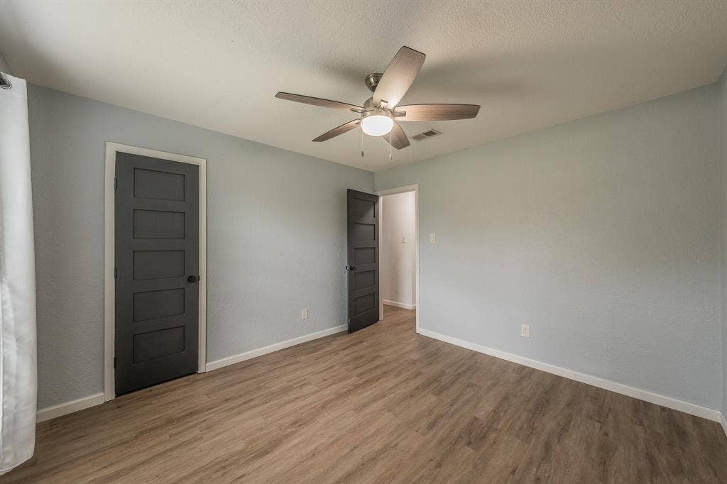 5612 Macgregor Drive, Haltom City, TX 76148 Interior room featuring wood-finish flooring, light blue wall paint, and a ceiling fan with integrated lighting