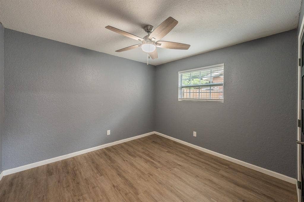 5612 Macgregor Drive, Haltom City, TX 76148 Room featuring wood-finish flooring, a ceiling fan with integrated lighting, a window with horizontal blinds, and a neutral wall color