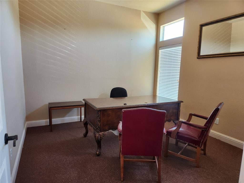 1905 W Ennis Avenue, #301, Ennis, TX 75119 Carpeted room featuring a decorative wood desk, crown molding, and a transom window