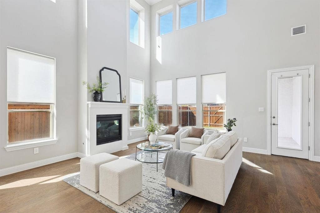 Living area with high ceilings, multiple windows, a built-in fireplace, and wood-finish flooring