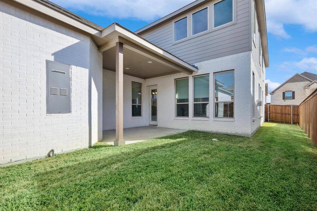 Covered patio area with white brick exterior and wood fencing