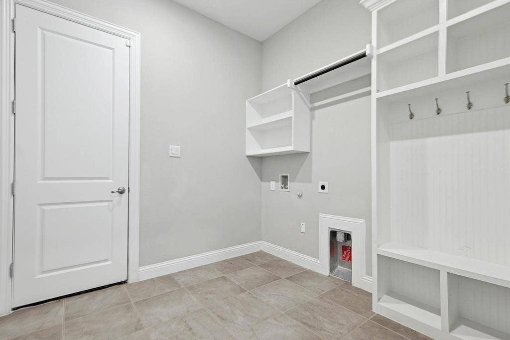 Laundry area featuring a built-in bench with storage, integrated shelving, coat hooks, and a hanging rod