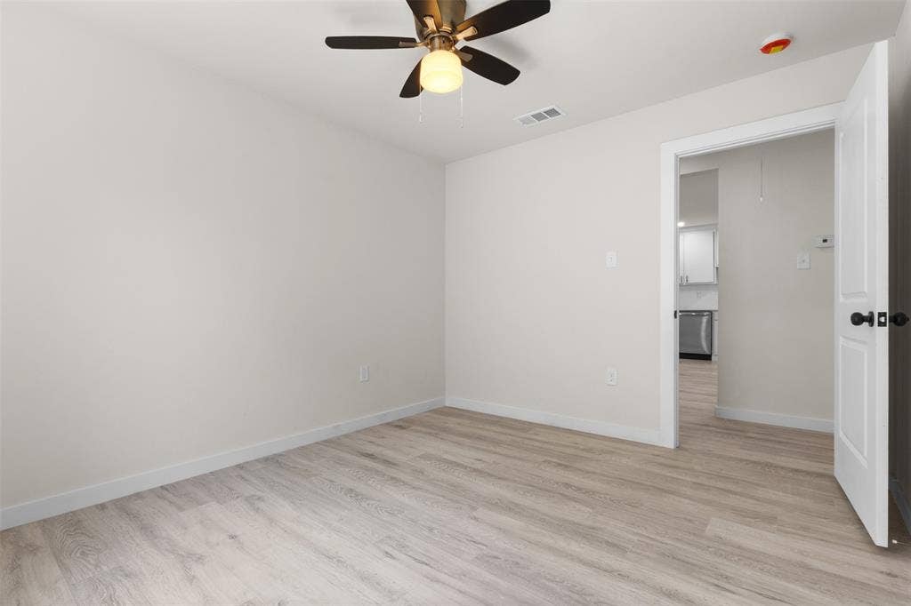 106 Mount Shasta Street, Dallas, TX 75211 Light wood-finish flooring, ceiling fan with integrated lighting, and white walls