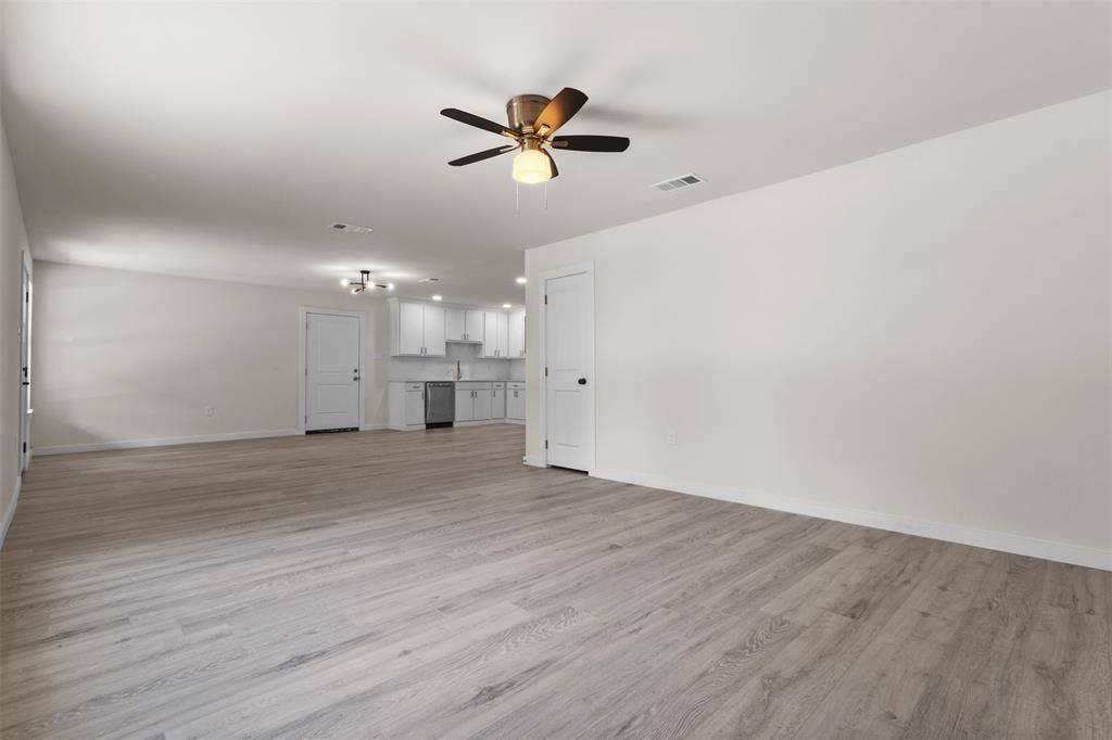 106 Mount Shasta Street, Dallas, TX 75211 Spacious room featuring wood-finish flooring, a ceiling fan, and white walls
