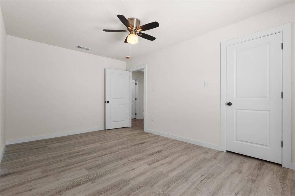 106 Mount Shasta Street, Dallas, TX 75211 Neutral-toned wood-finish flooring, white walls, and a ceiling fan with integrated lighting