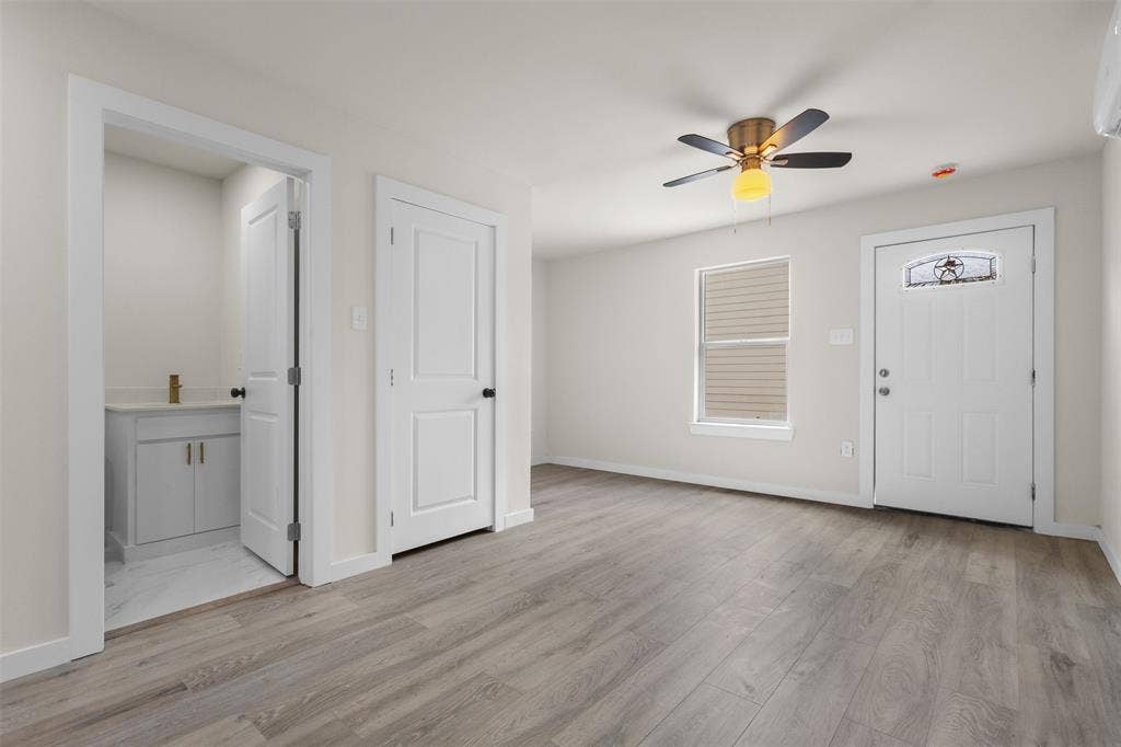 106 Mount Shasta Street, Dallas, TX 75211 Wood-finish flooring, white paneled doors, ceiling fan with integrated lighting, and a front entry door with decorative glass