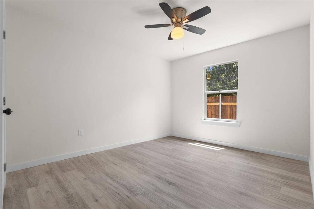 106 Mount Shasta Street, Dallas, TX 75211 Spacious room featuring wood-finish flooring, a ceiling fan with integrated lighting, and a window providing natural illumination