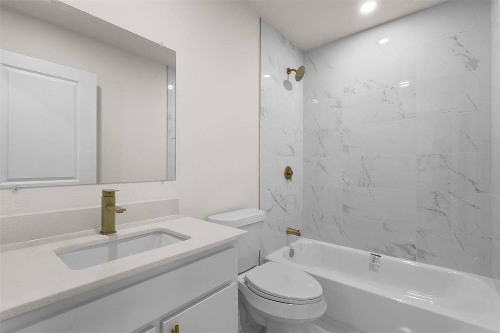 106 Mount Shasta Street, Dallas, TX 75211 White vanity with integrated sink, gold-finish faucet, and coordinating gold-finish hardware