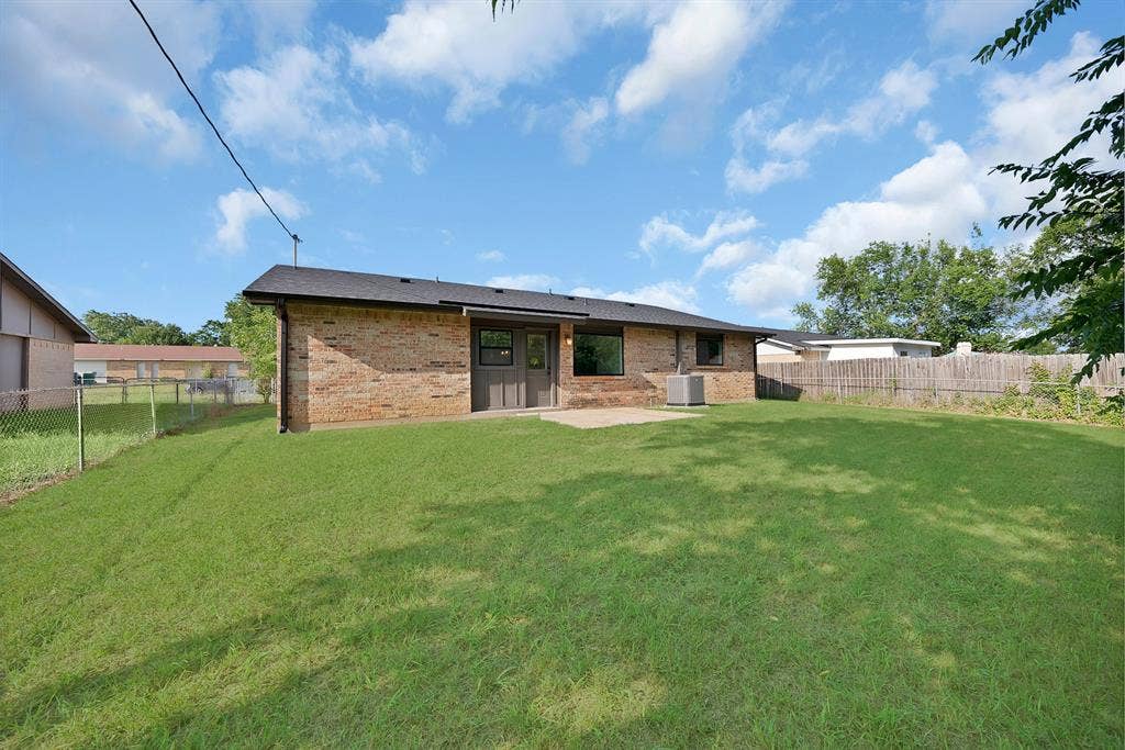 132 Yorkshire Drive, Cedar Hill, TX 75104 Expansive backyard featuring a manicured lawn, brick exterior, and a concrete patio