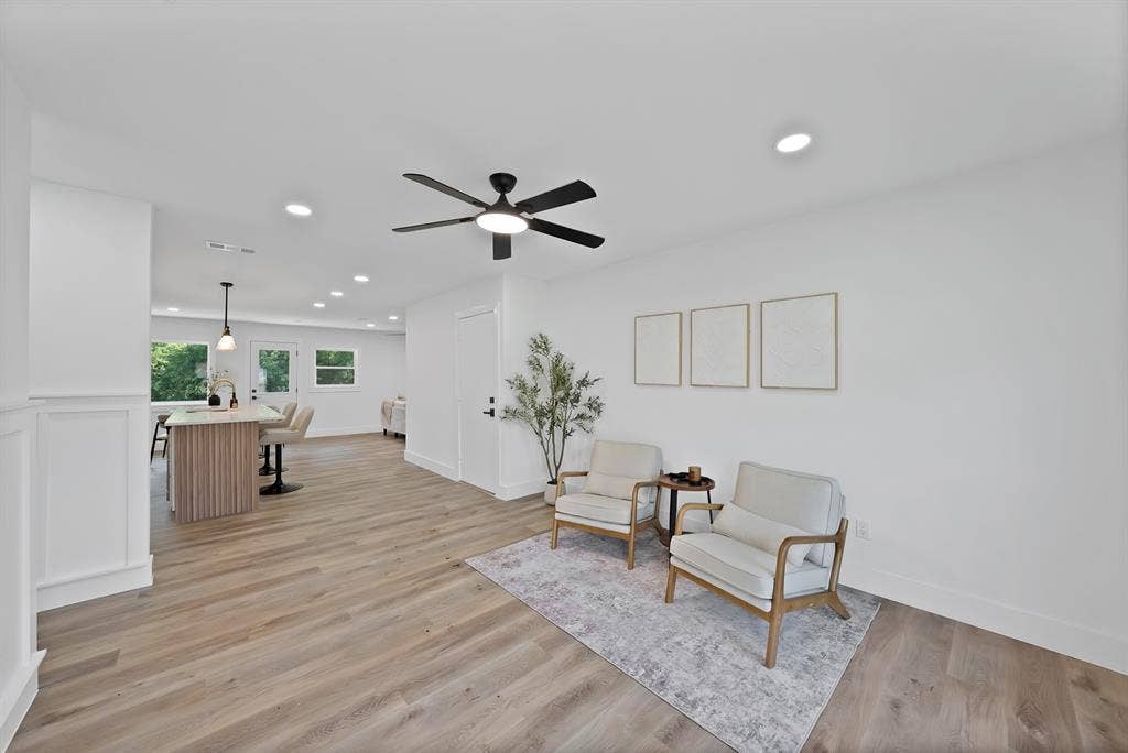 132 Yorkshire Drive, Cedar Hill, TX 75104 Open-concept interior featuring wood-finish flooring, recessed lighting, a modern ceiling fan, white paneled wainscoting, and a kitchen island with pendant lighting