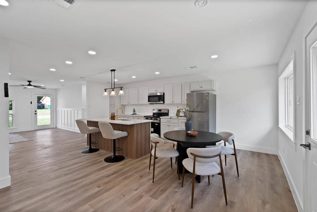 132 Yorkshire Drive, Cedar Hill, TX 75104 Open-concept kitchen and living area featuring wood-finish flooring, recessed lighting, and a kitchen island with a fluted wood base